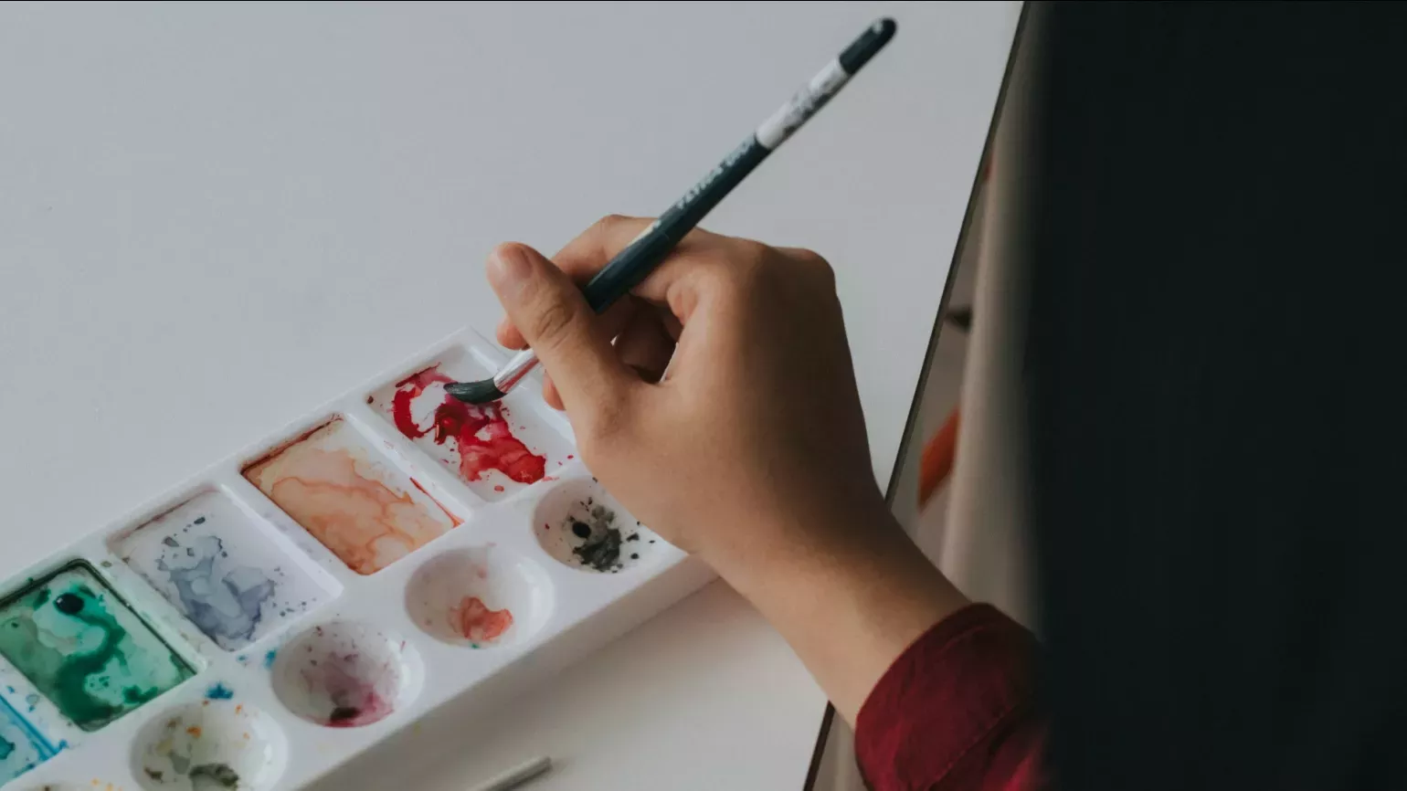 2B or not 2B art classes © Rifqi Ali Ridho A hand dipping a paintbrush into a palette