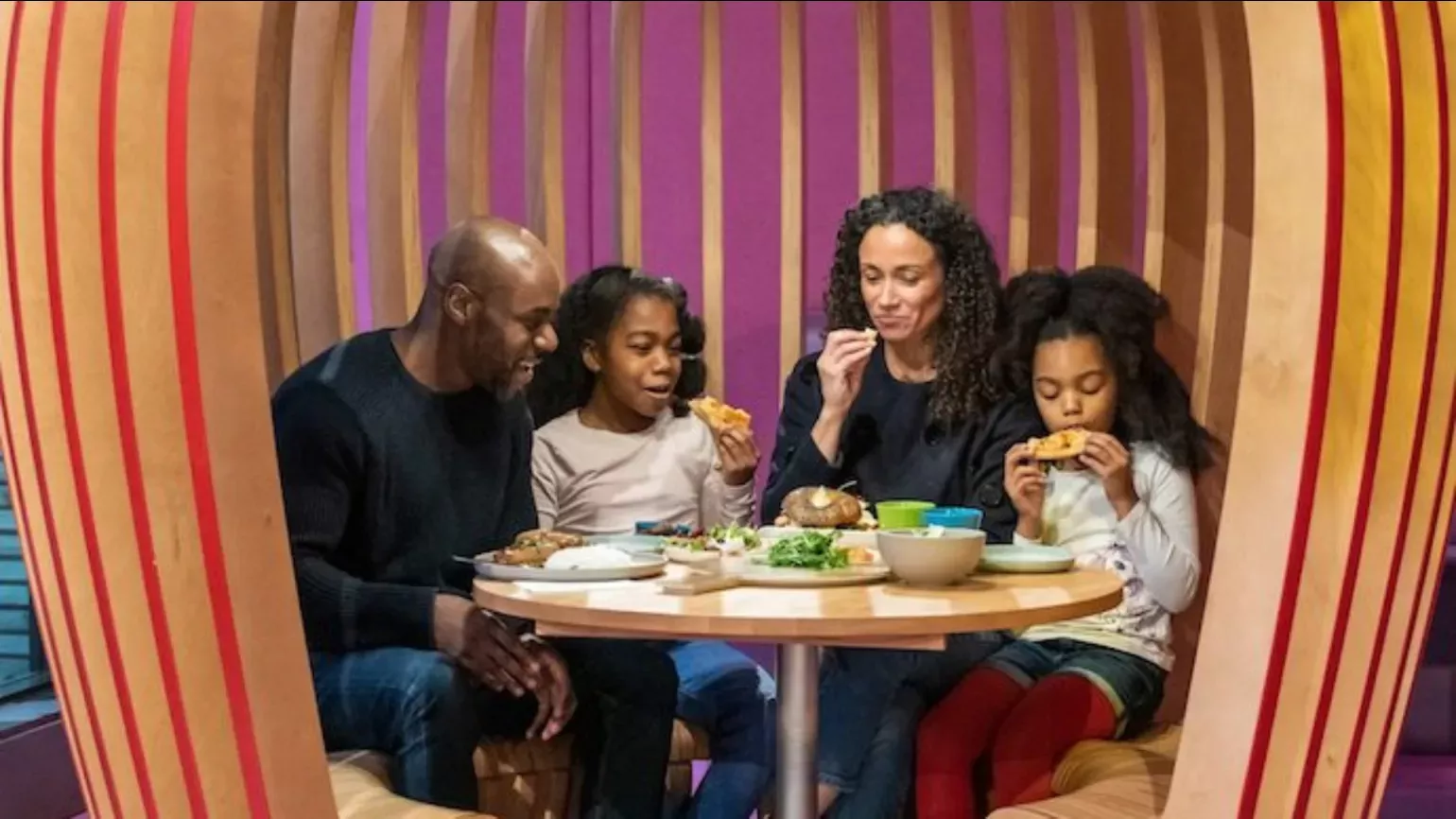 The Family Kitchen and Shop © RBG Kew A family eat a meal at a colourful restaurant booth