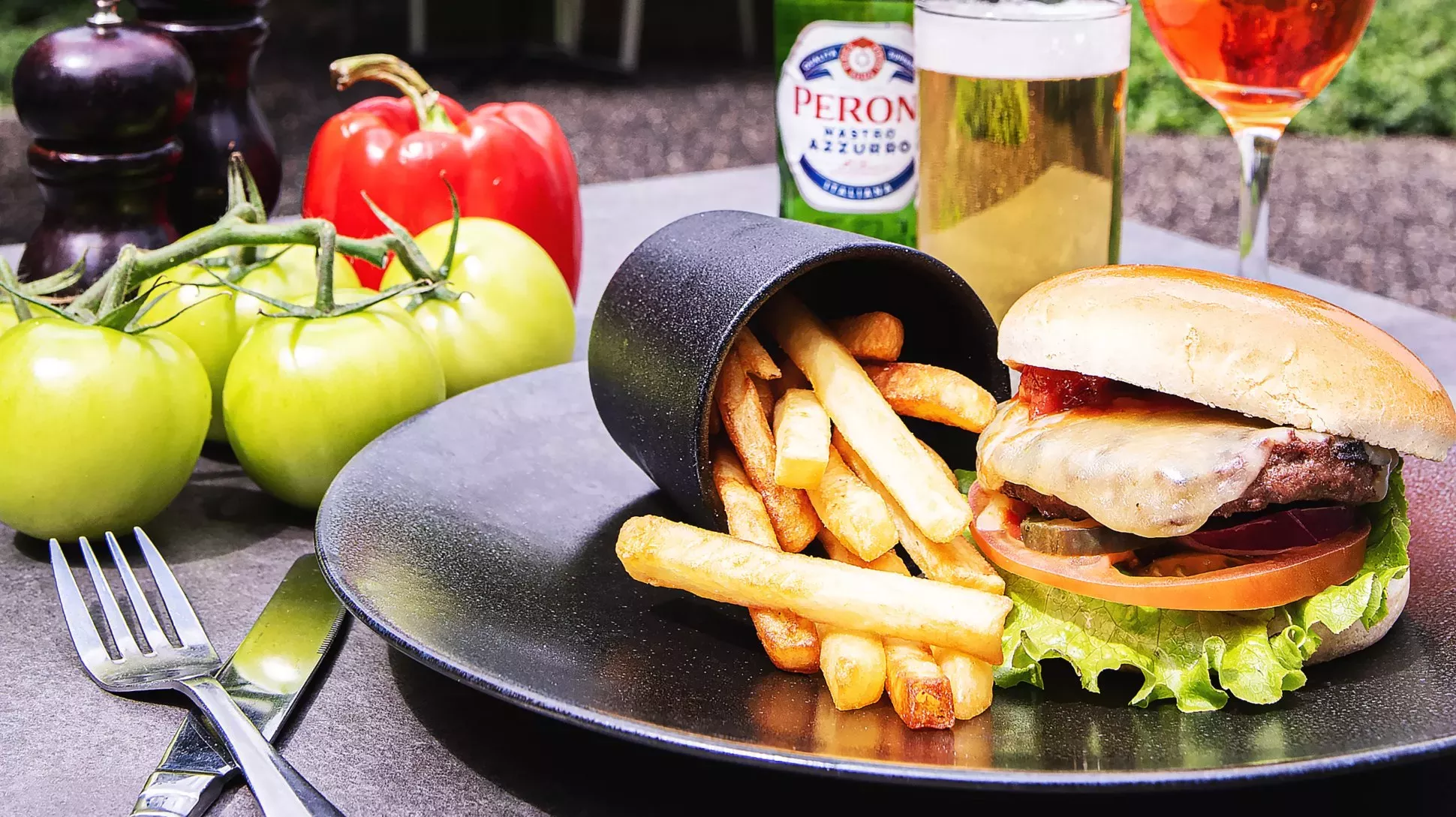 A meal at the Pavilion at Kew Gardens A burger and chips on a plate with large tomatoes in the background