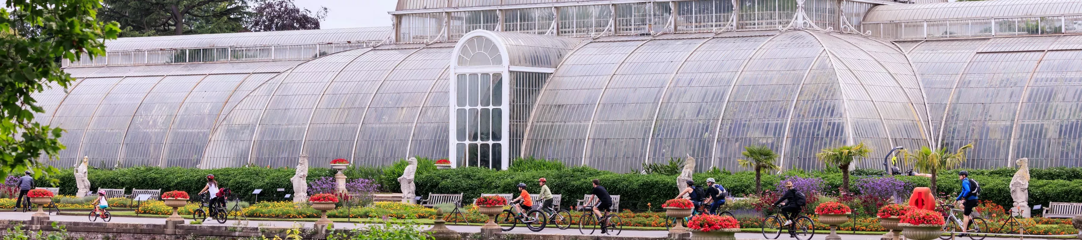 Summer Cycle © RBG Kew People on bikes outside a large glasshouse