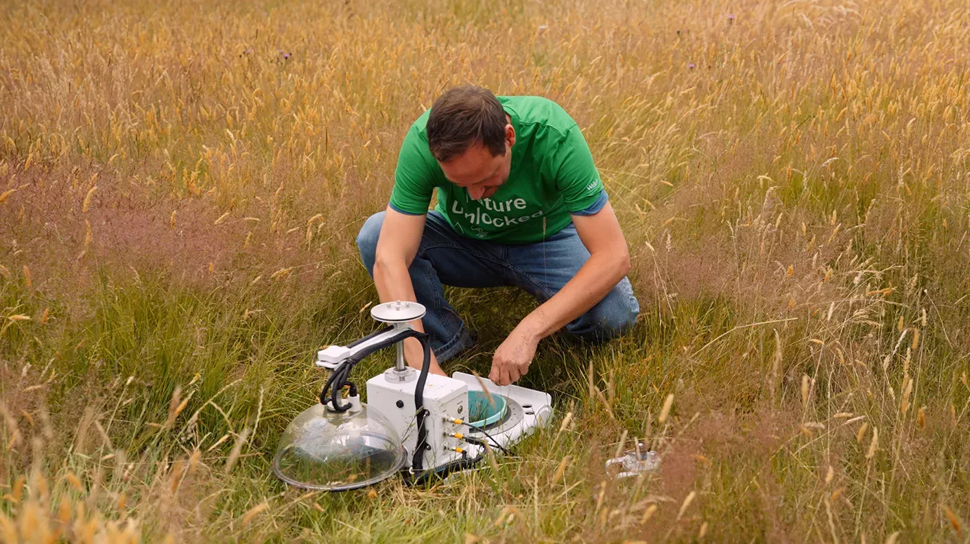 Gas flux monitoring, Visual Air © RBG Kew Dr Gary Egan kneels over a gas flux monitoring chamber in a field