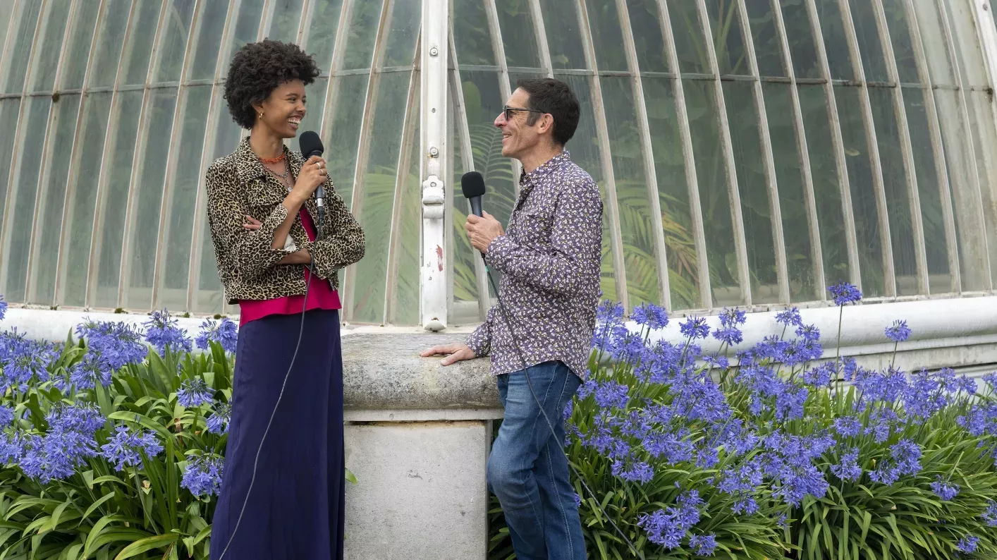 Unearthed Presenter Poppy Okocha and guest Jeremy Torz © RBG Kew Two people standing outside the Kew's Pal House speaking into microphones