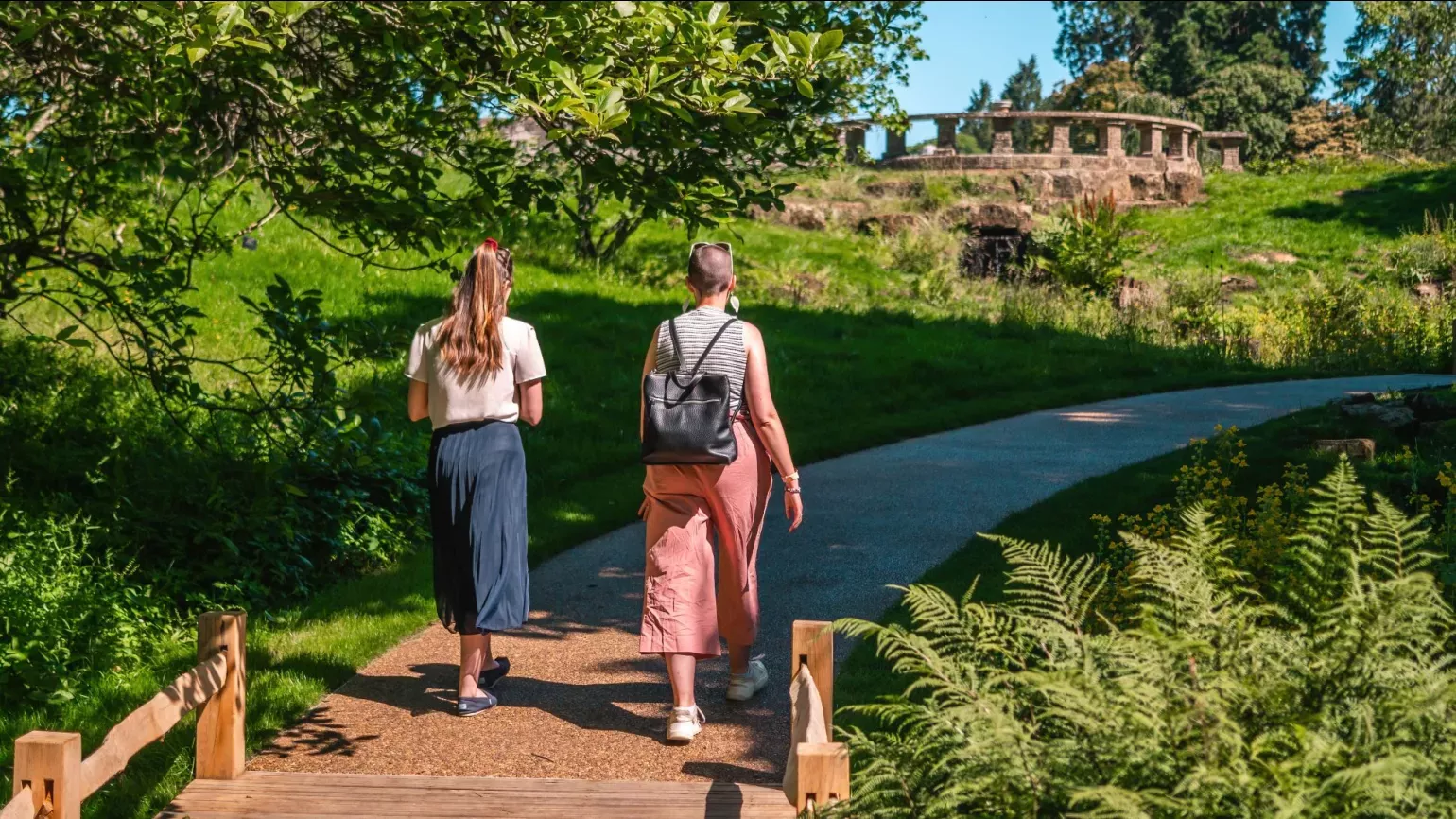 The Slips at Wakehurst, Visual Air © RBG Kew A pair of people walk along a path surrounded by trees