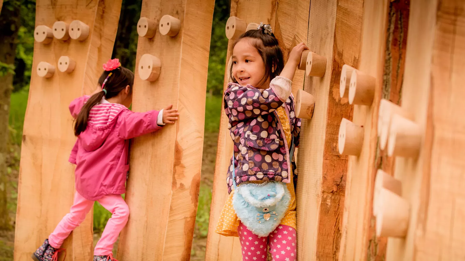 Tree Trunk Trek, Jim Holden © RBG Kew Two girls climb across a wooden activity trail.
