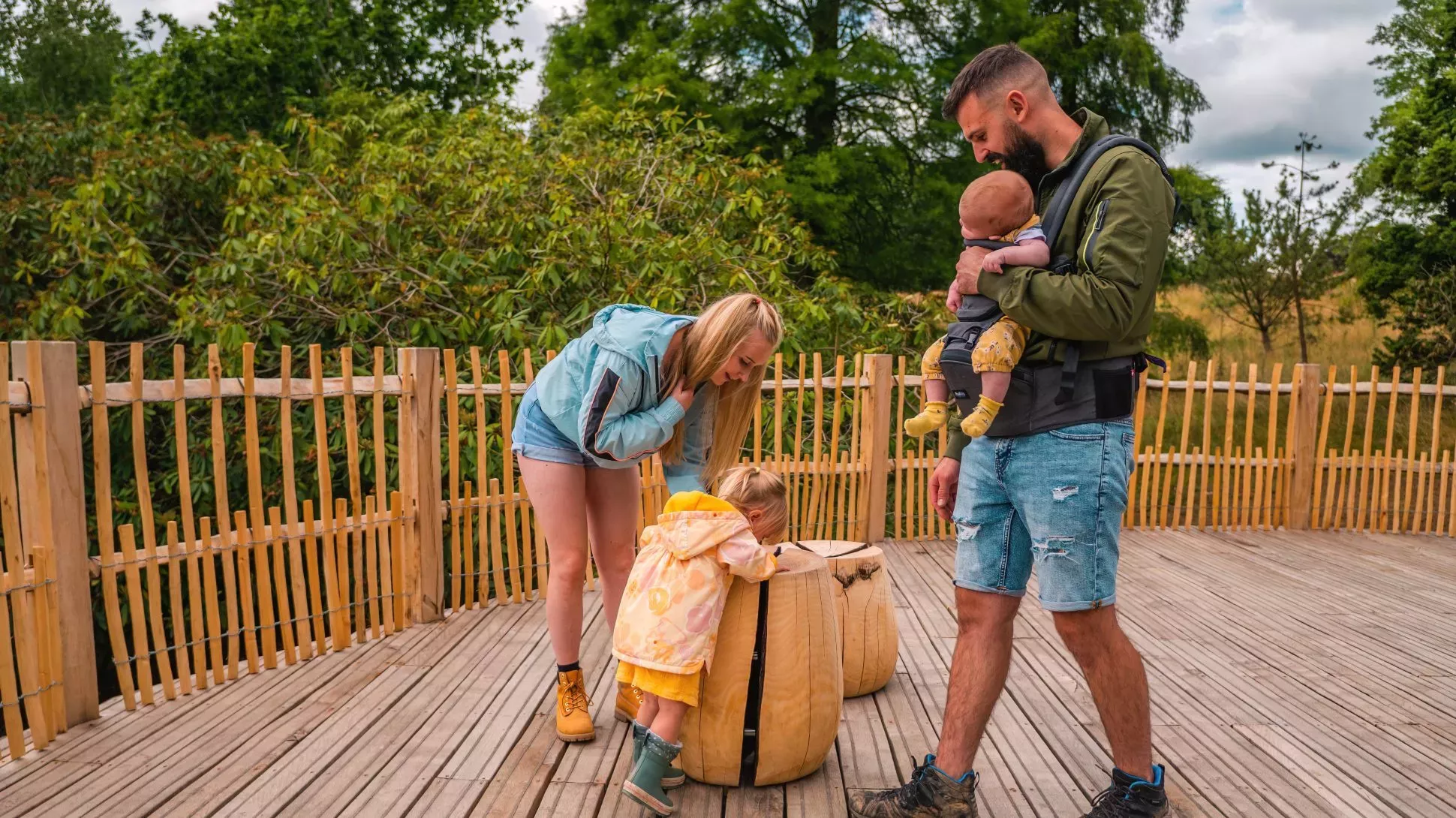 Ash timber at Wakehurst has been used for new seating at Westwood View Point, Visual Air © RBG Kew A family investigate wooden seats on a wooden decked viewing platform